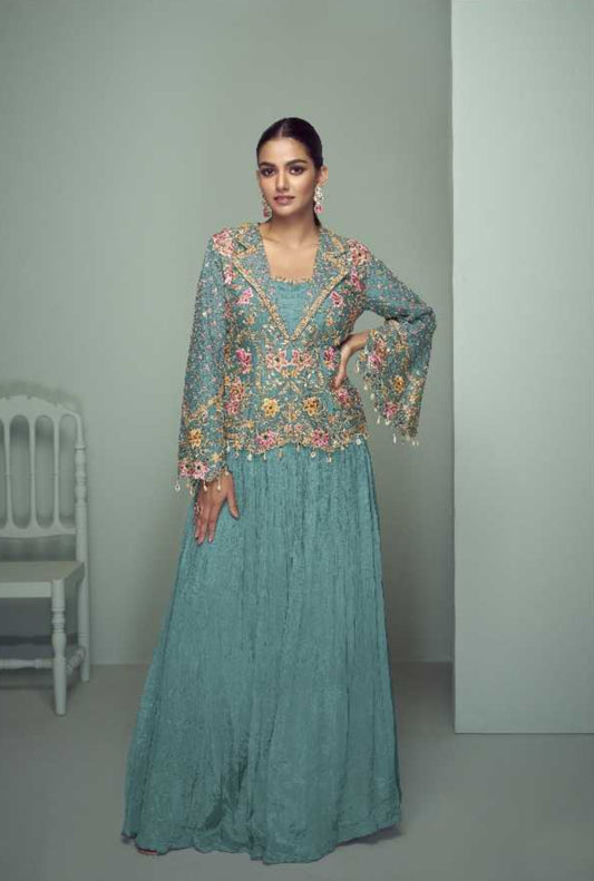 Woman wearing a teal embroidered outfit with Gujkaaya branding on a light gray background.