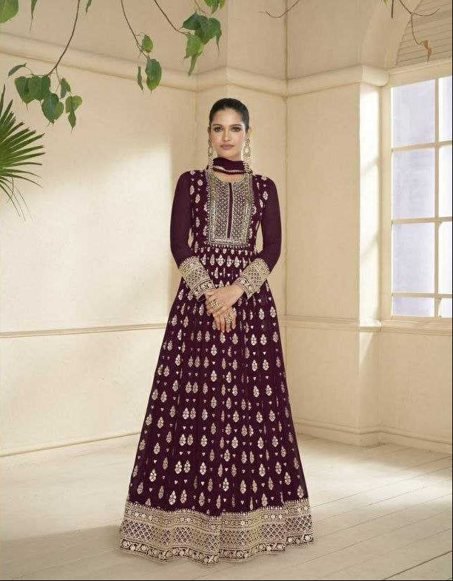 Woman in a traditional outfit with intricate designs in a well-lit room.