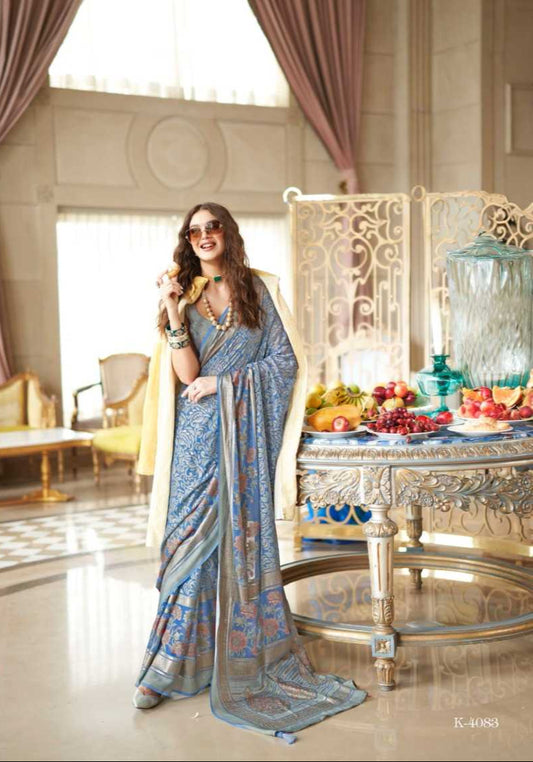 Woman in a blue saree with a decorative background, surrounded by fruits and a table setting.