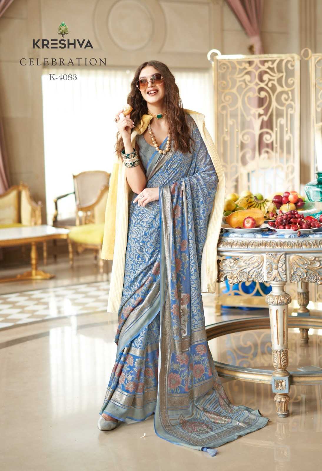 Woman in a blue saree with a decorative setting in the background