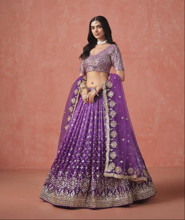 Purple embroidered traditional outfit with gold details on a pink background