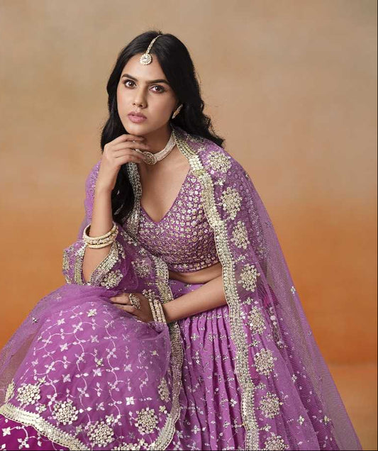 Woman wearing a purple embroidered traditional outfit with a beige background