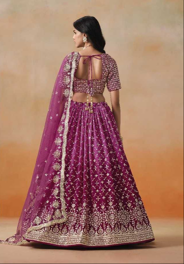 Purple embroidered traditional outfit with gold details on a beige background