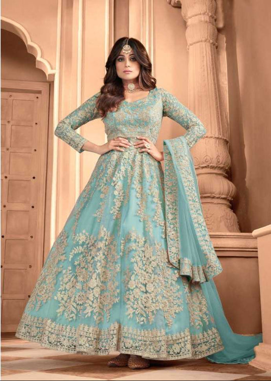 Woman wearing a light blue embroidered traditional outfit with a matching dupatta.