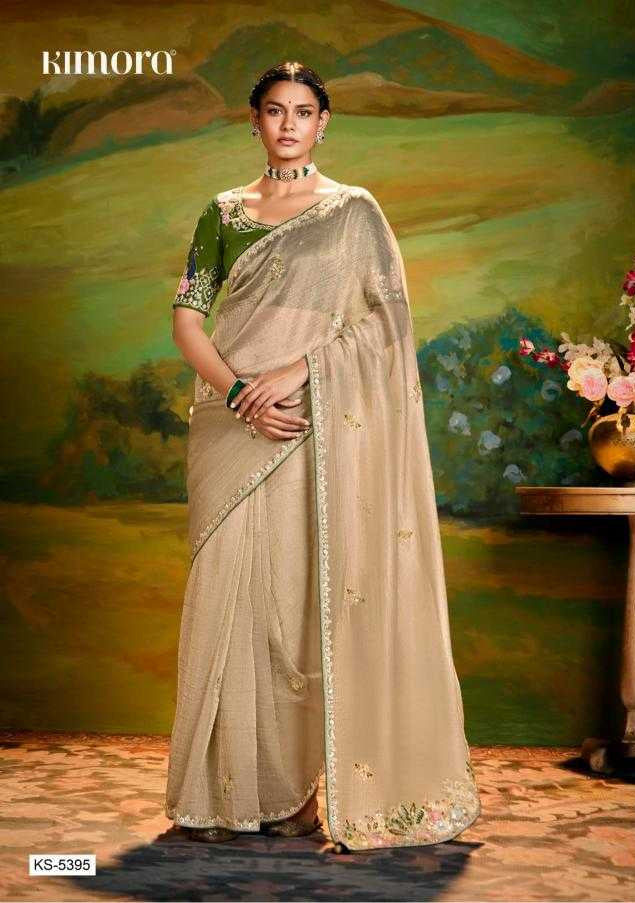 Woman wearing a traditional saree with a green blouse and beige border against a scenic background.