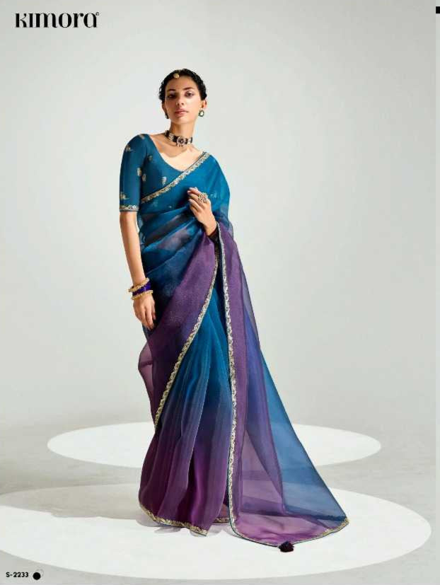 Two women wearing blue sarees with purple borders on a white background