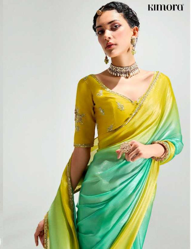 Woman wearing a yellow and green saree with a white background