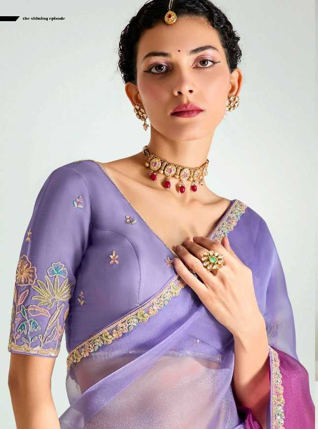 Woman wearing a traditional purple saree with gold details on a white background