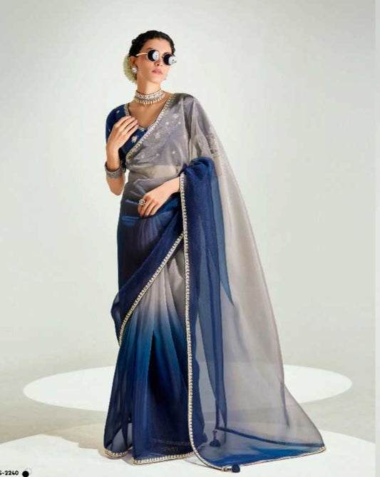 Two women wearing blue and gray sarees with sunglasses on a white background, featuring the brand 'Kimora'.