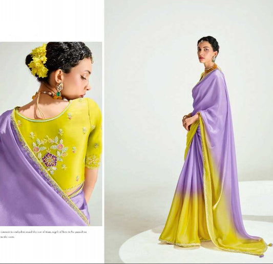 Woman wearing a purple and yellow saree with floral decorations, brand 'Kinnara' visible.