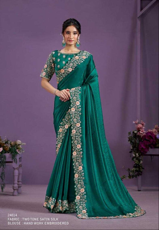 Green saree with floral patterns worn by a model against a purple background