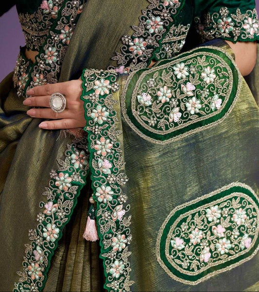 Green embroidered saree with a close-up of intricate designs on a purple background