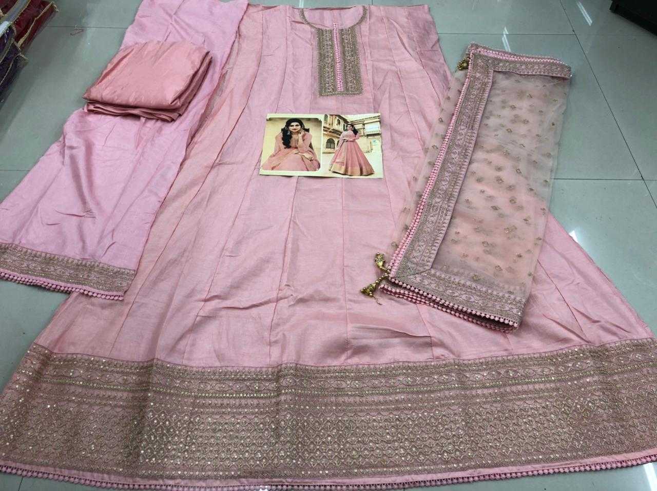 Pink traditional outfit with embroidered details on a tiled floor
