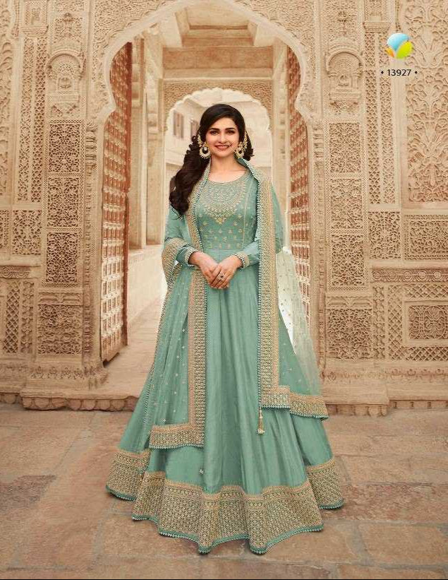Woman in a light blue traditional outfit standing in an ornate architectural setting.