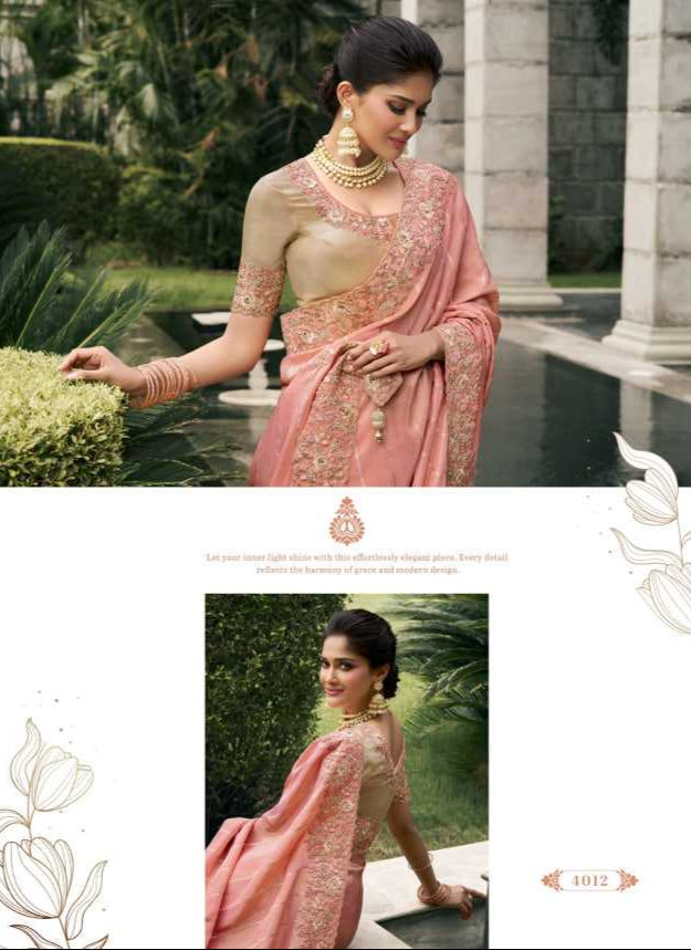 Woman in a pink saree with gold embroidery standing in an outdoor setting.