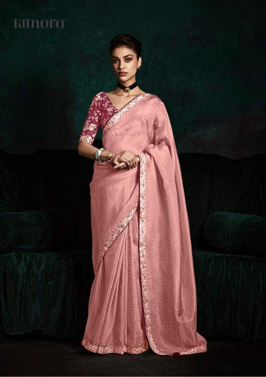 Woman wearing a pink saree with a dark background
