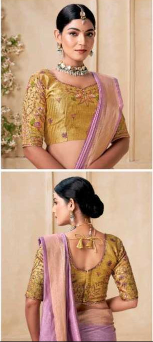 Woman wearing a traditional outfit with a gold blouse and pink saree in an elegant setting.